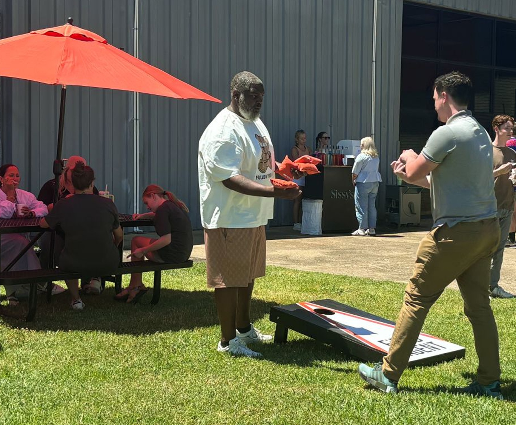 People playing cornhole at an outdoor company gathering shown on Storesight’s about page