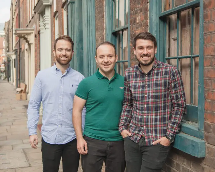 Three members of Storm2’s founding team standing outside a brick building