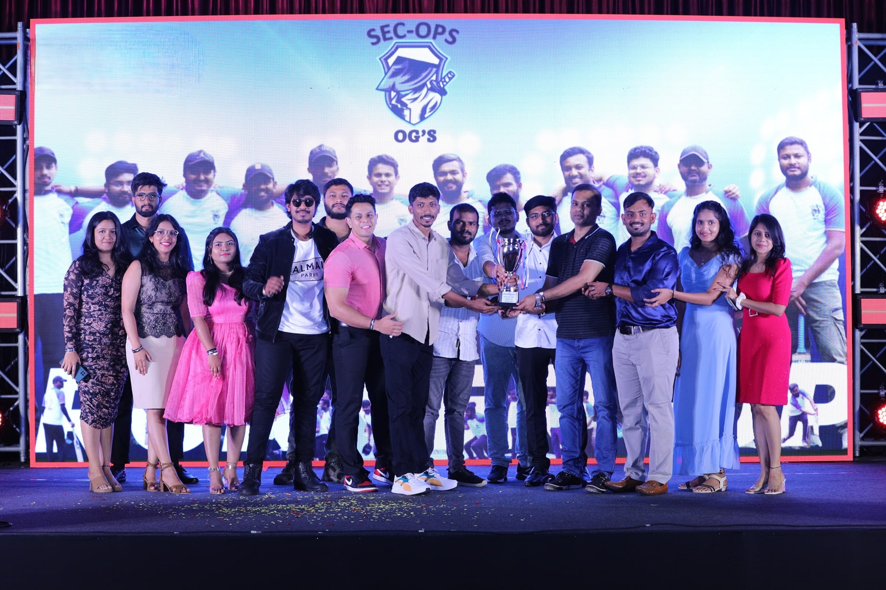 Stratogent colleagues gather on stage around a trophy at a company event