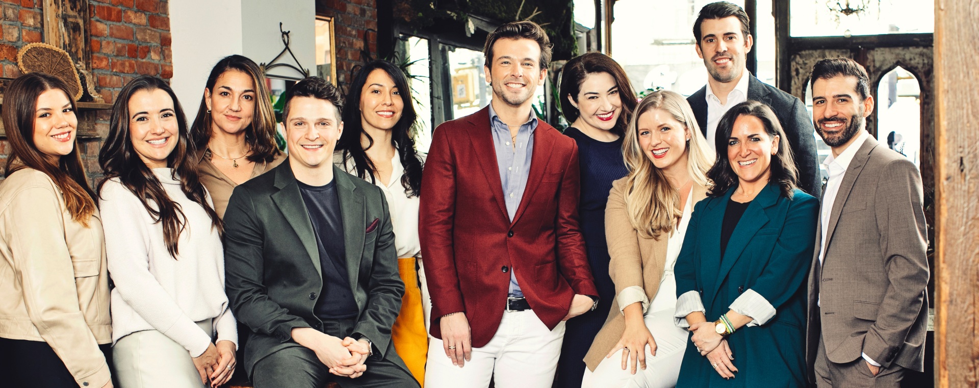 The Whitman and Roberson real estate partner team posing in a brick-walled interior