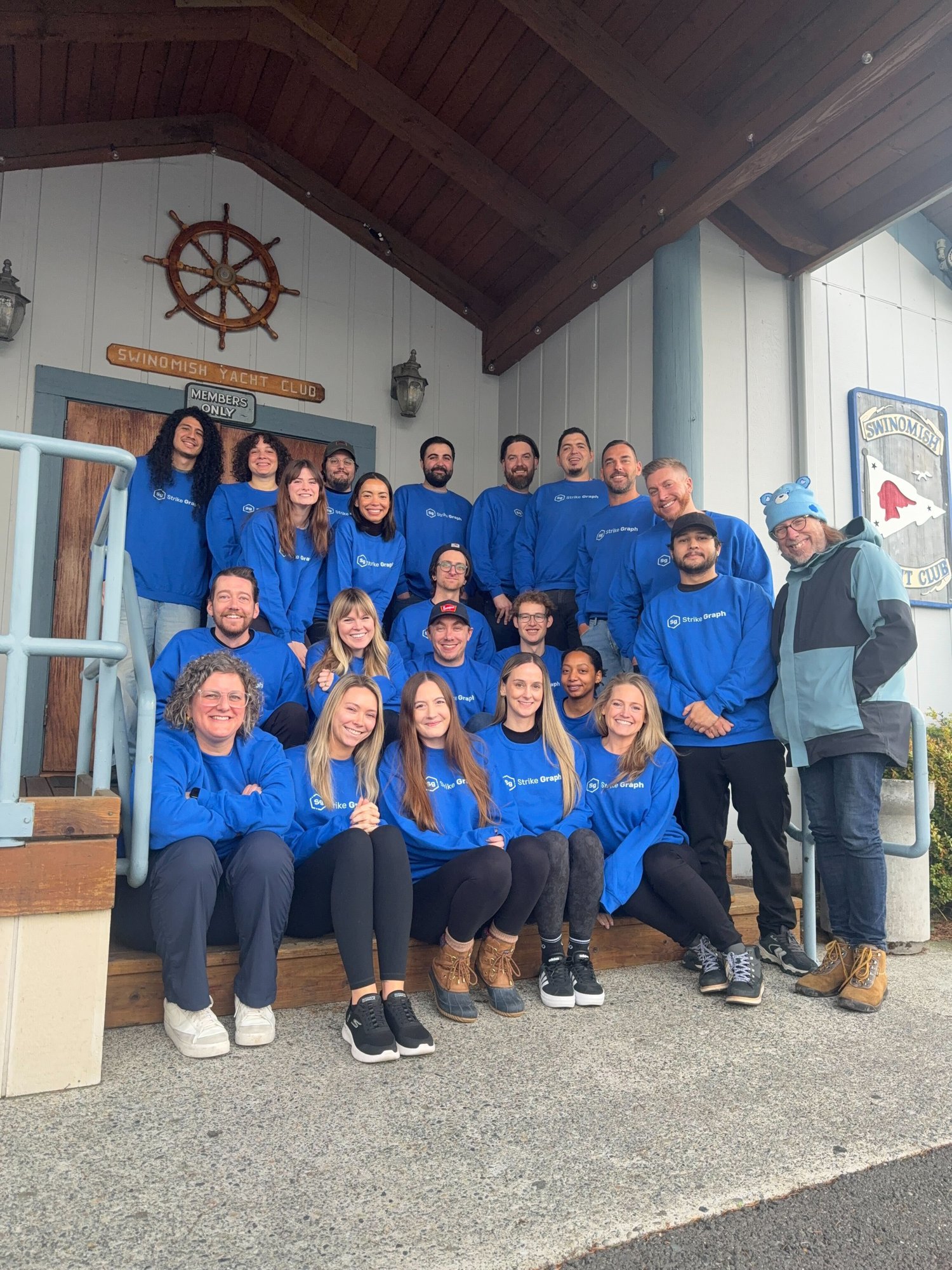 Strike Graph team wearing blue company sweatshirts outside the Swinomish Yacht Club