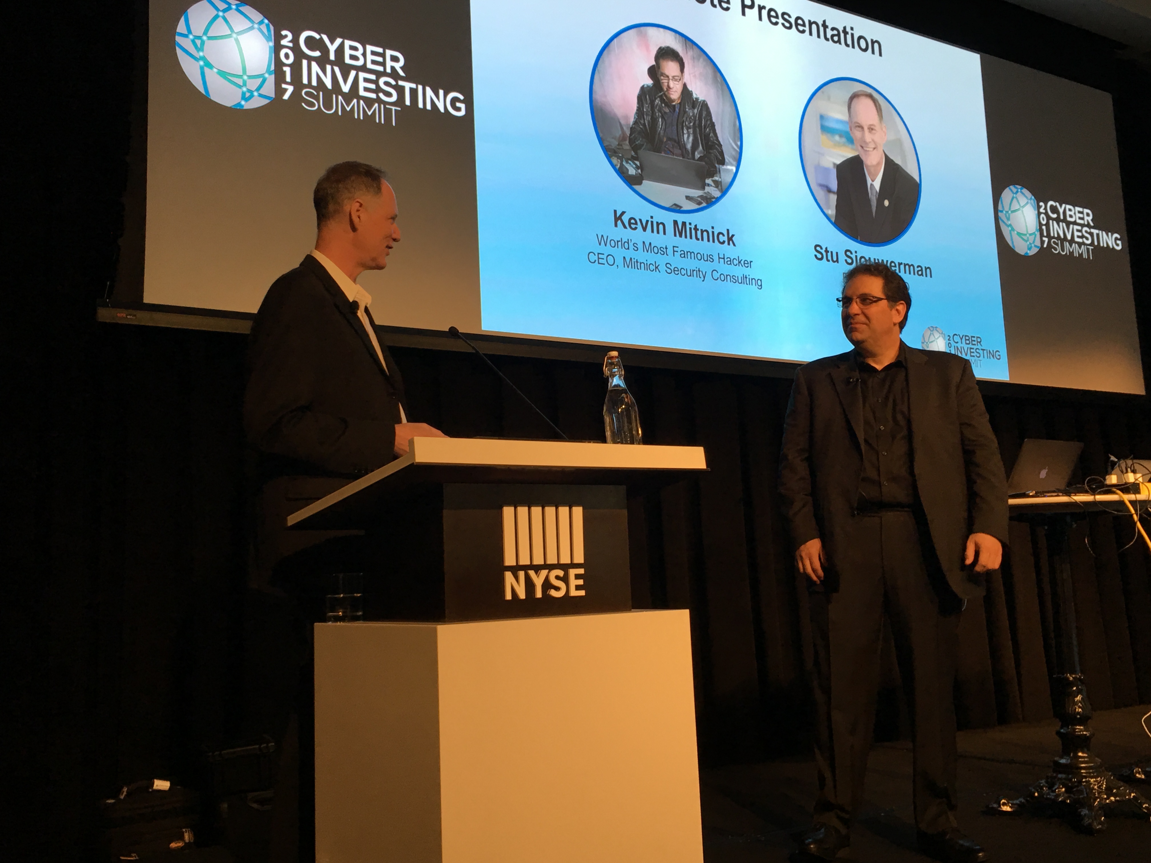 Stu Sjouwerman at the lectern with Kevin Mitnick on stage at the 2017 Cyber Investing Summit at the New York Stock Exchange.