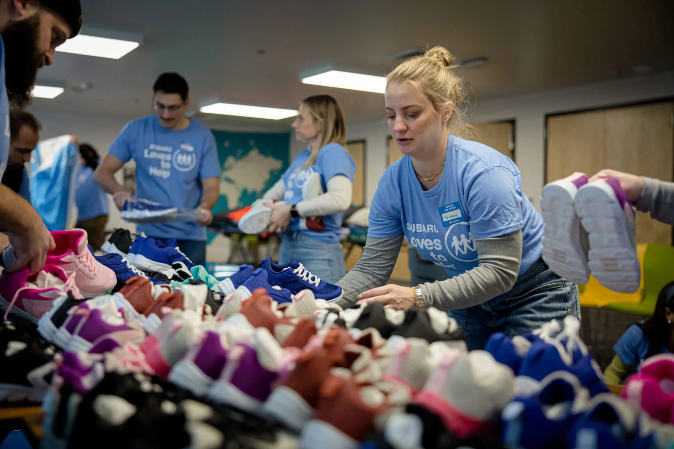 Subaru volunteers sort shoes during a Subaru Loves to Help event