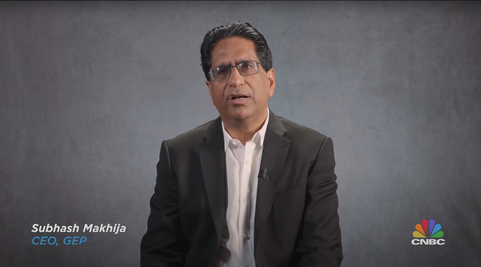 Subhash Makhija speaking during a CNBC interview, seated against a gray backdrop