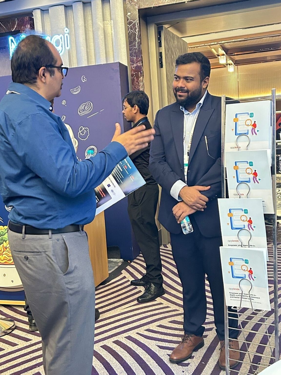 Subho Halder listening to a visitor at an Appknox conference booth