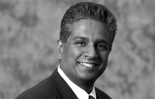 An archival black-and-white press photograph of Subrah Iyar smiling in a suit
