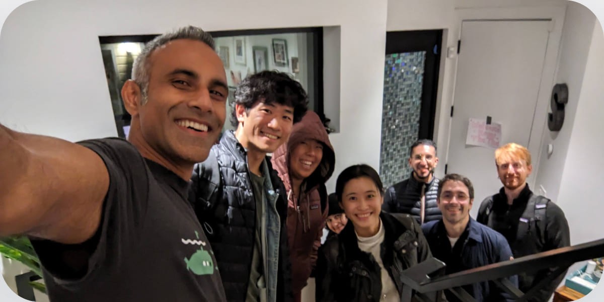 Subscript team members smiling together in a group photograph
