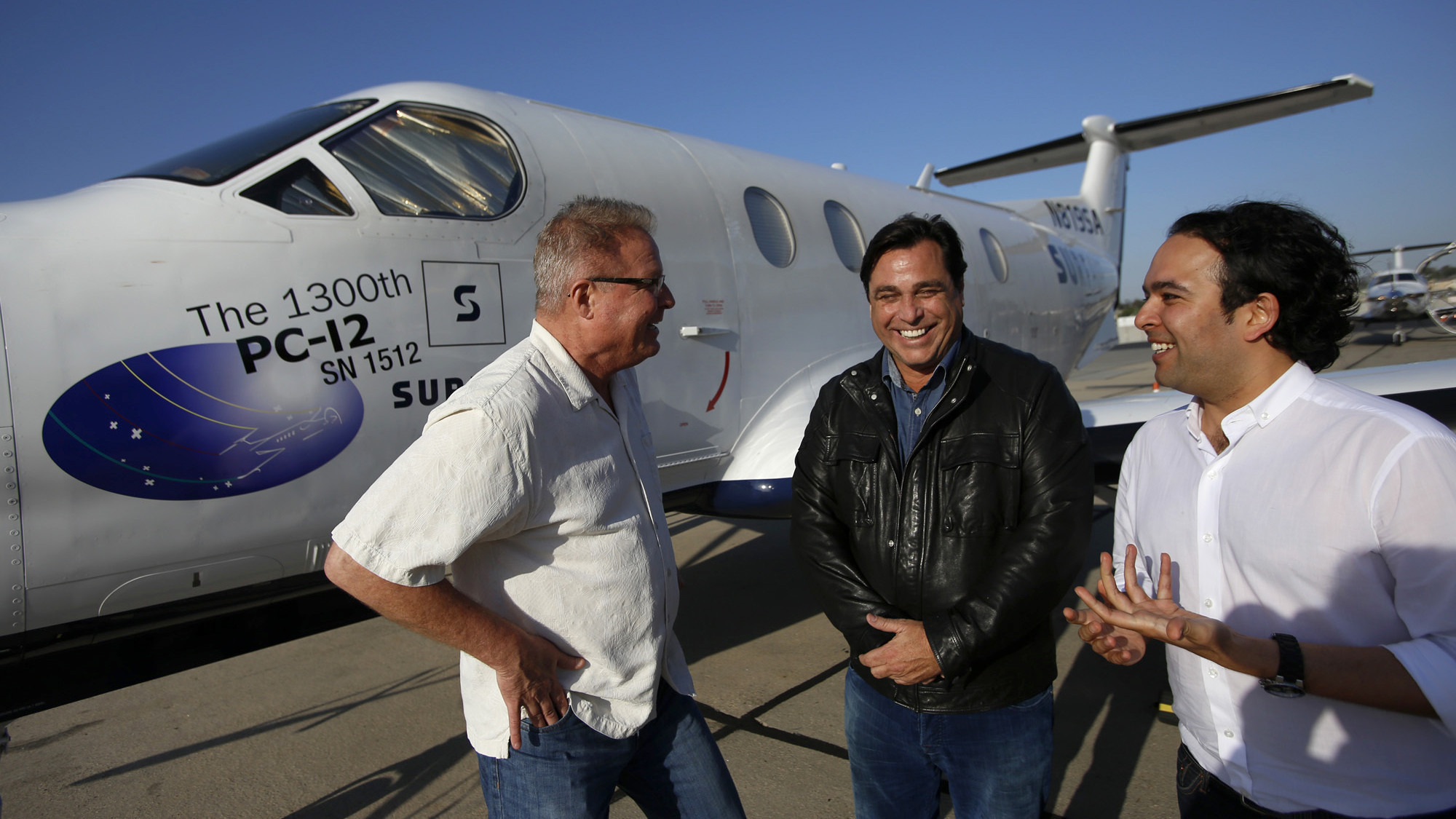 Sudhin Shahani, at right, talking with William Woodward and Jeff Potter beside a Surf Air Pilatus PC-12 at Hawthorne Municipal Airport