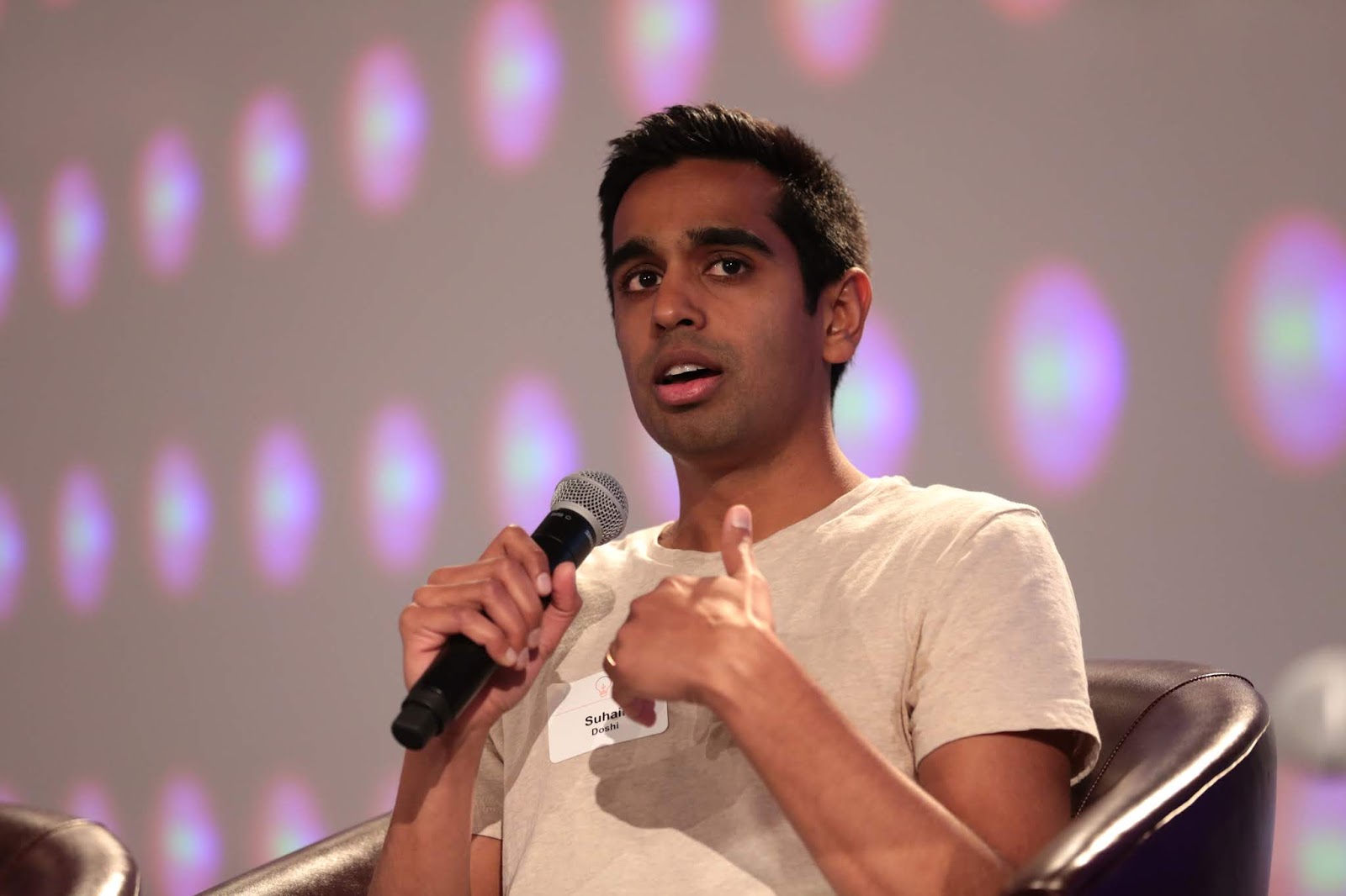 Suhail Doshi speaking into a microphone during a seated panel discussion