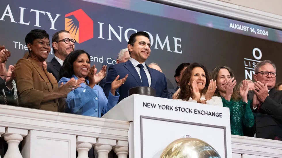 Sumit Roy and Realty Income colleagues applaud at the New York Stock Exchange anniversary celebration