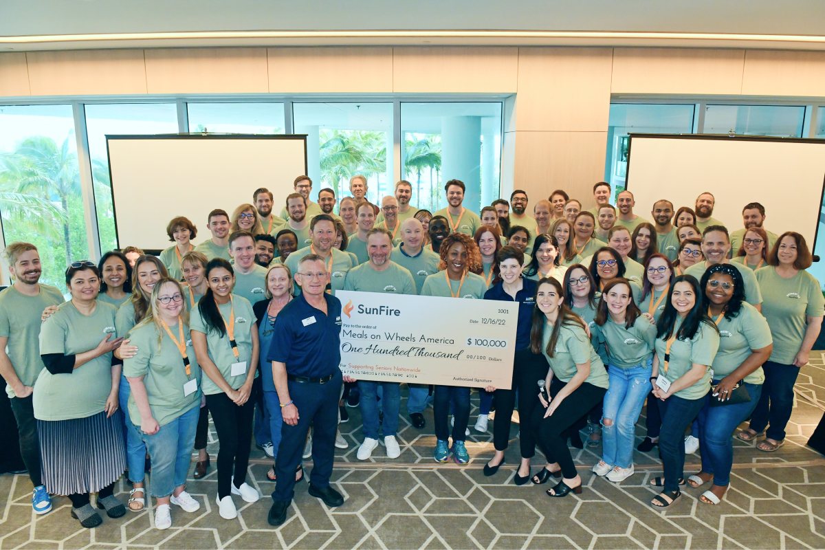 SunFire employees and Meals on Wheels America representatives holding a large donation check