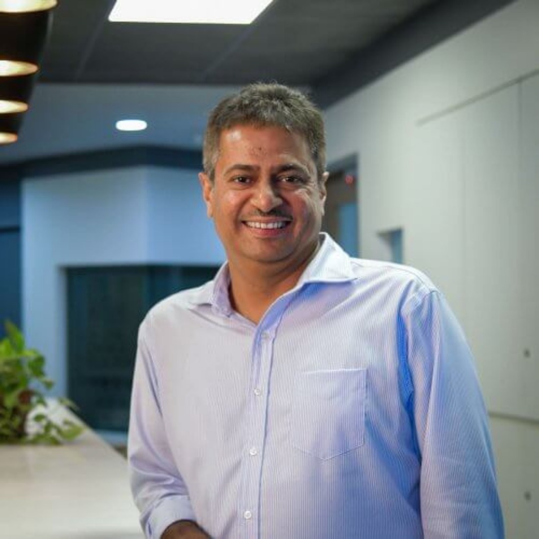 Sunil Thomas smiling in a modern office