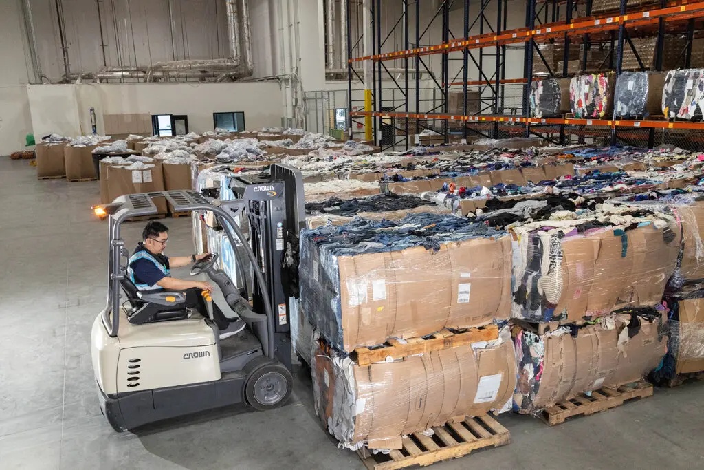 Forklift beside stacked bales of recovered textiles in a Supercircle warehouse