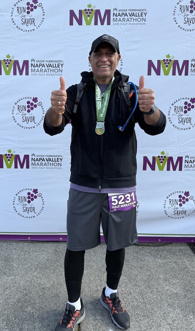 Suresh Balasubramanian smiles with his medal after the 2025 Napa Valley Half Marathon