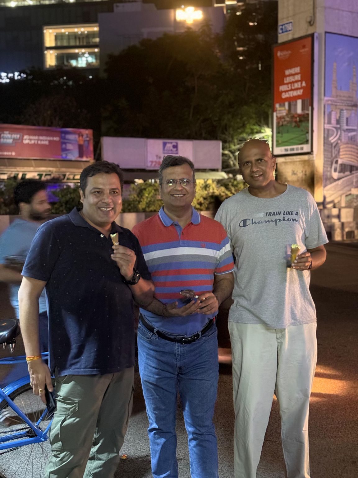 Suresh Kakarla, at right, holding an ice-cream cone beside two collaborators on a Hyderabad street