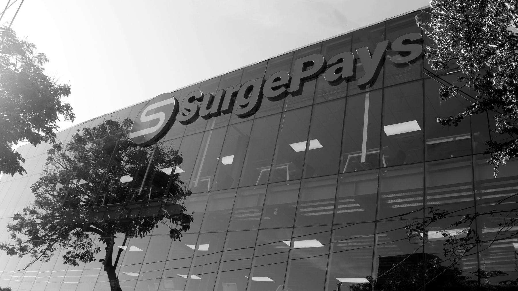 SurgePays operations center in El Salvador, with glass windows and company signage