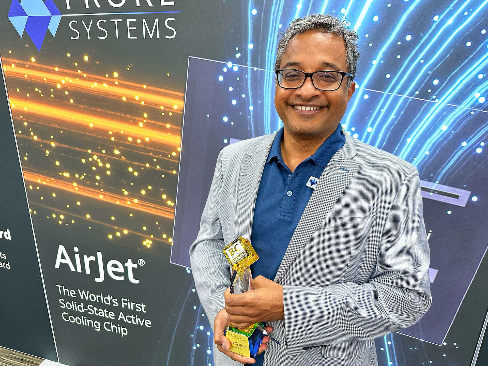 Suryaprakash Ganti smiling at an AirJet display while holding a Best Choice Award trophy
