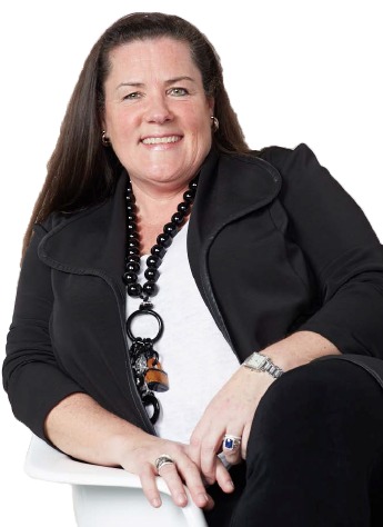 Susan Flinn Cobian seated and smiling in a black jacket