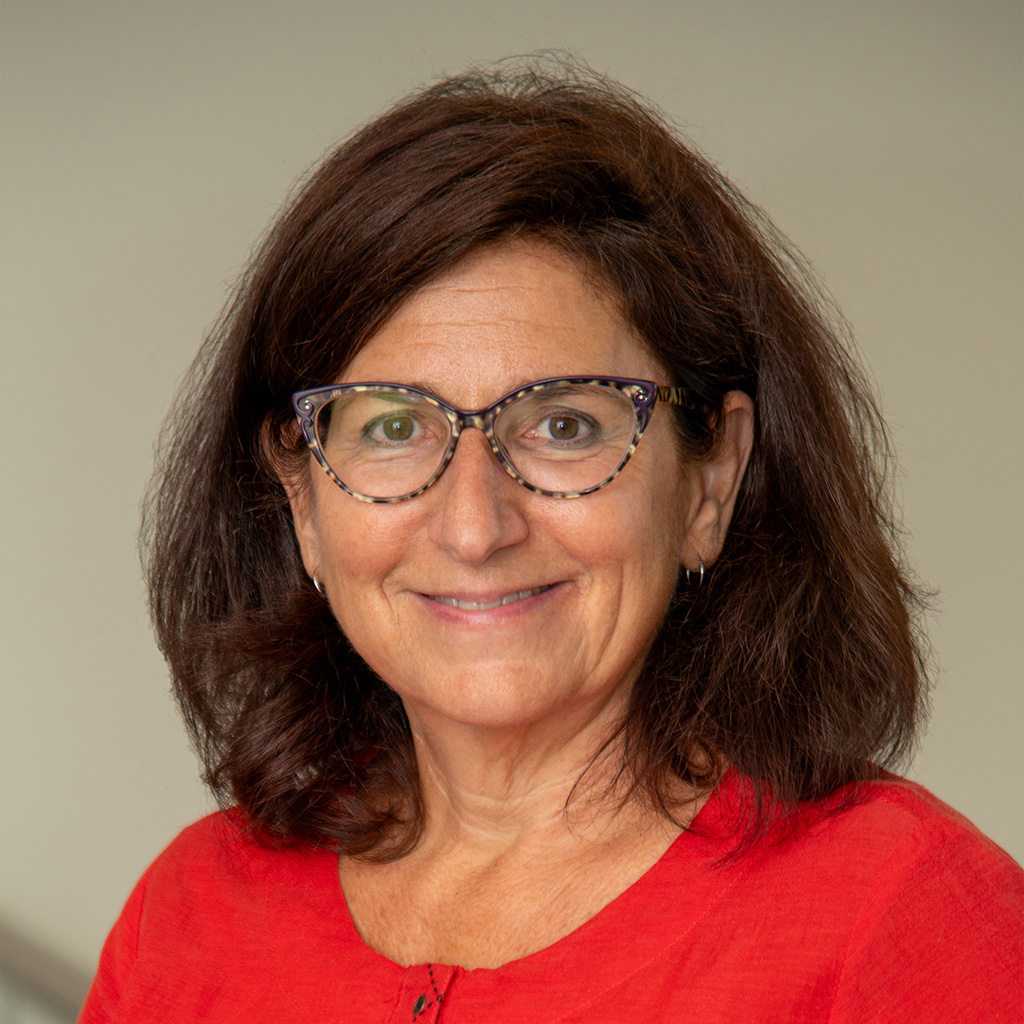 Susan Rawlings Molina wearing glasses and a red blouse in an earlier company photograph