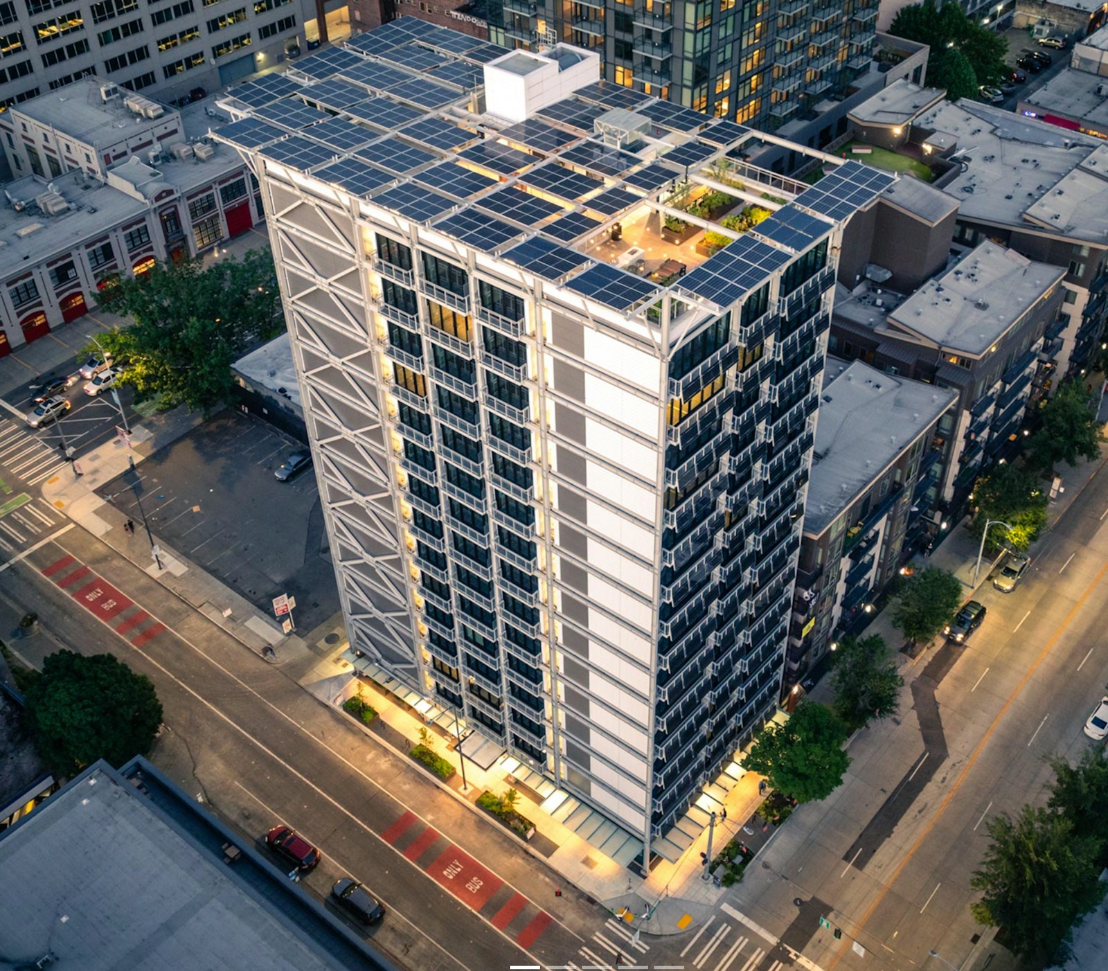 Aerial view of the completed 3zero3 apartment tower in Seattle, its roof covered in solar panels