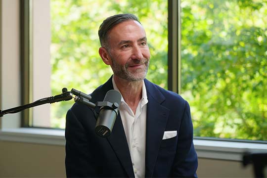 Mike Speiser seated beside a microphone during a Goldman Sachs interview