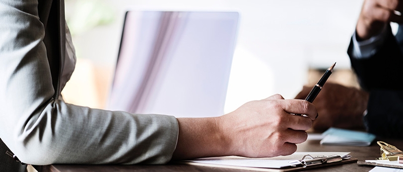 Two professionals reviewing transaction documents at a table