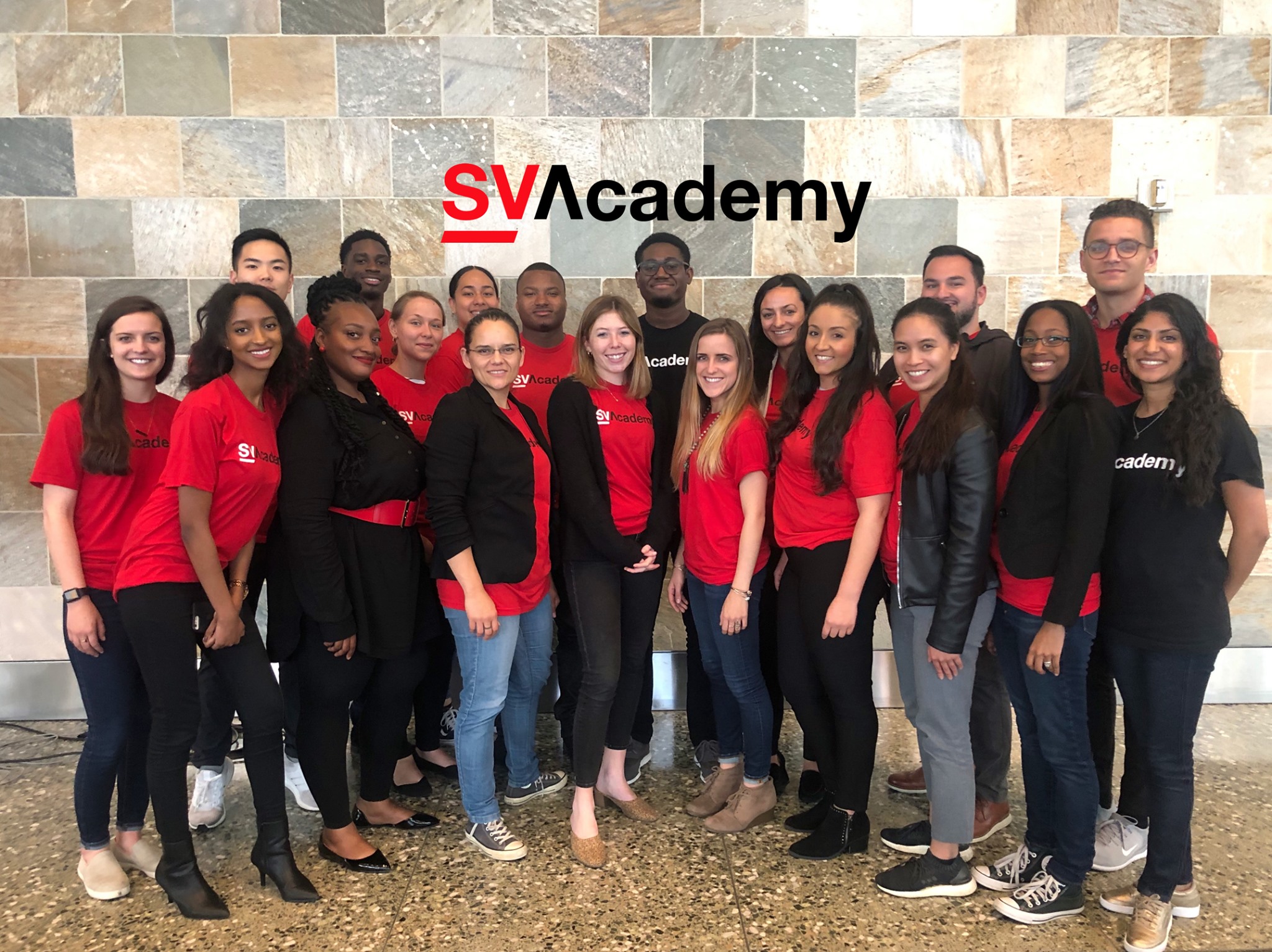 A group posing together in red and black SV Academy shirts