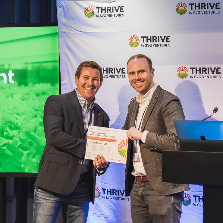 Two participants holding a Continuum Ag certificate for a THRIVE accelerator cohort