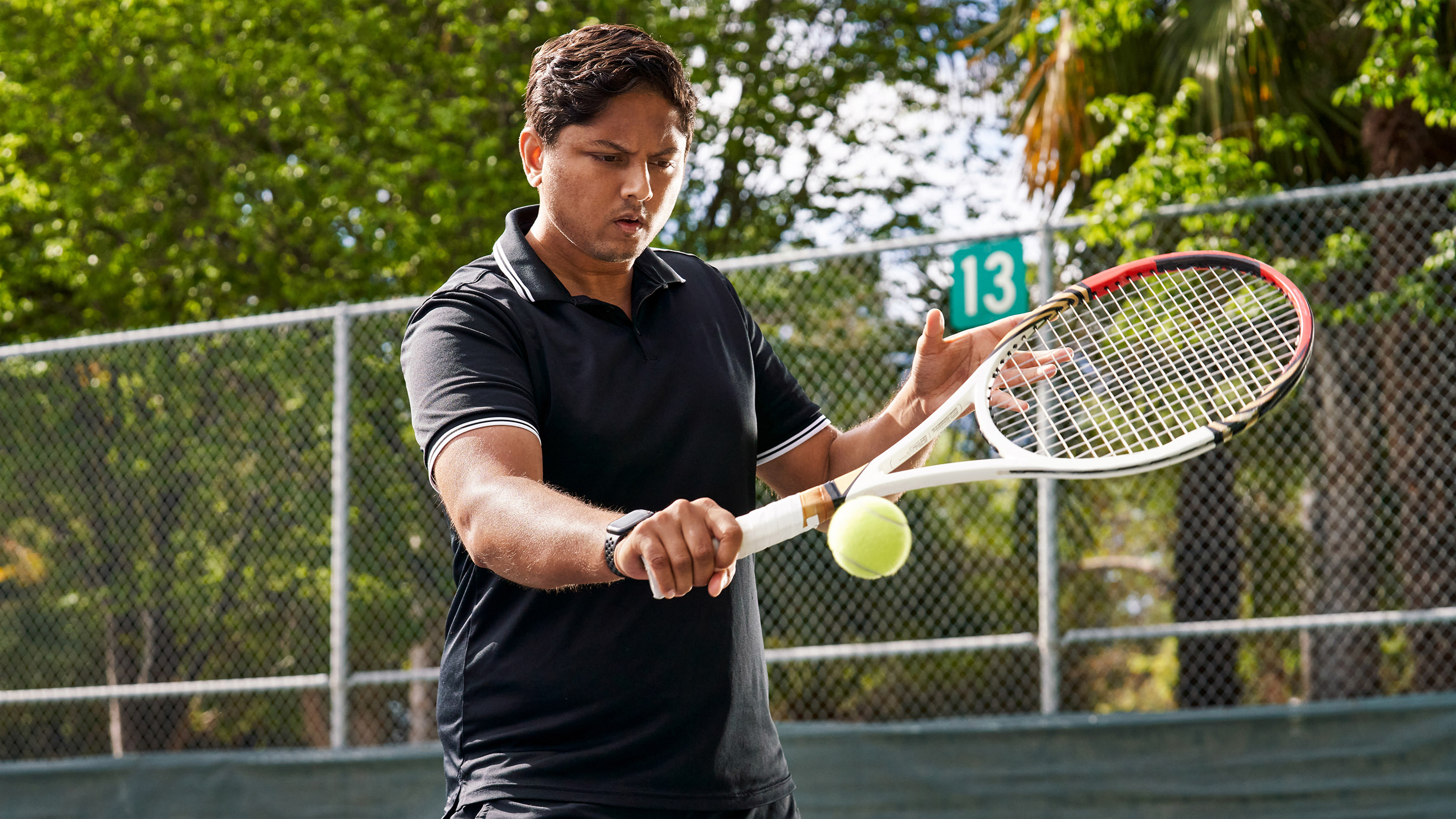 Swupnil Sahai hitting a tennis ball on an outdoor court