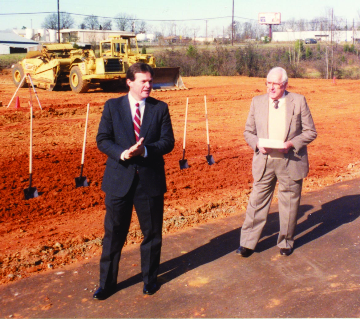 Swope Montgomery, left, at a bank groundbreaking beside a construction site