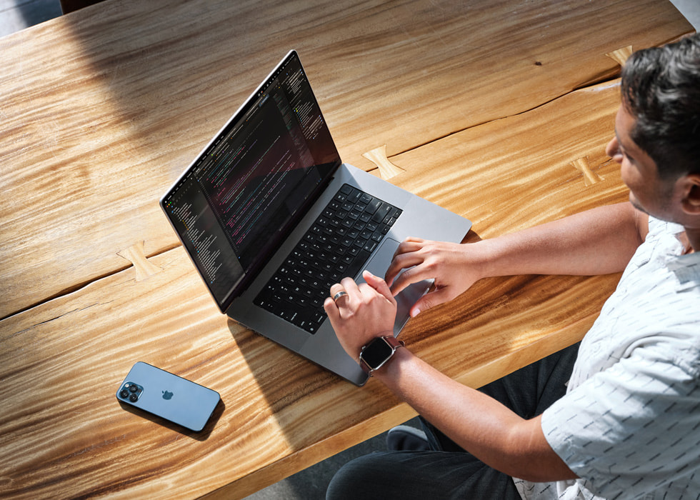 Swupnil Sahai working on a MacBook Pro at a desk
