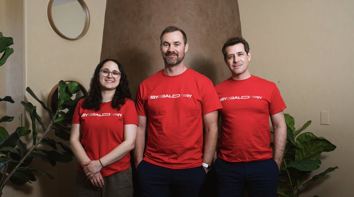 Sygaldry co-founders Idalia Friedson, Chad Rigetti, and Michael Keiser in red Sygaldry shirts
