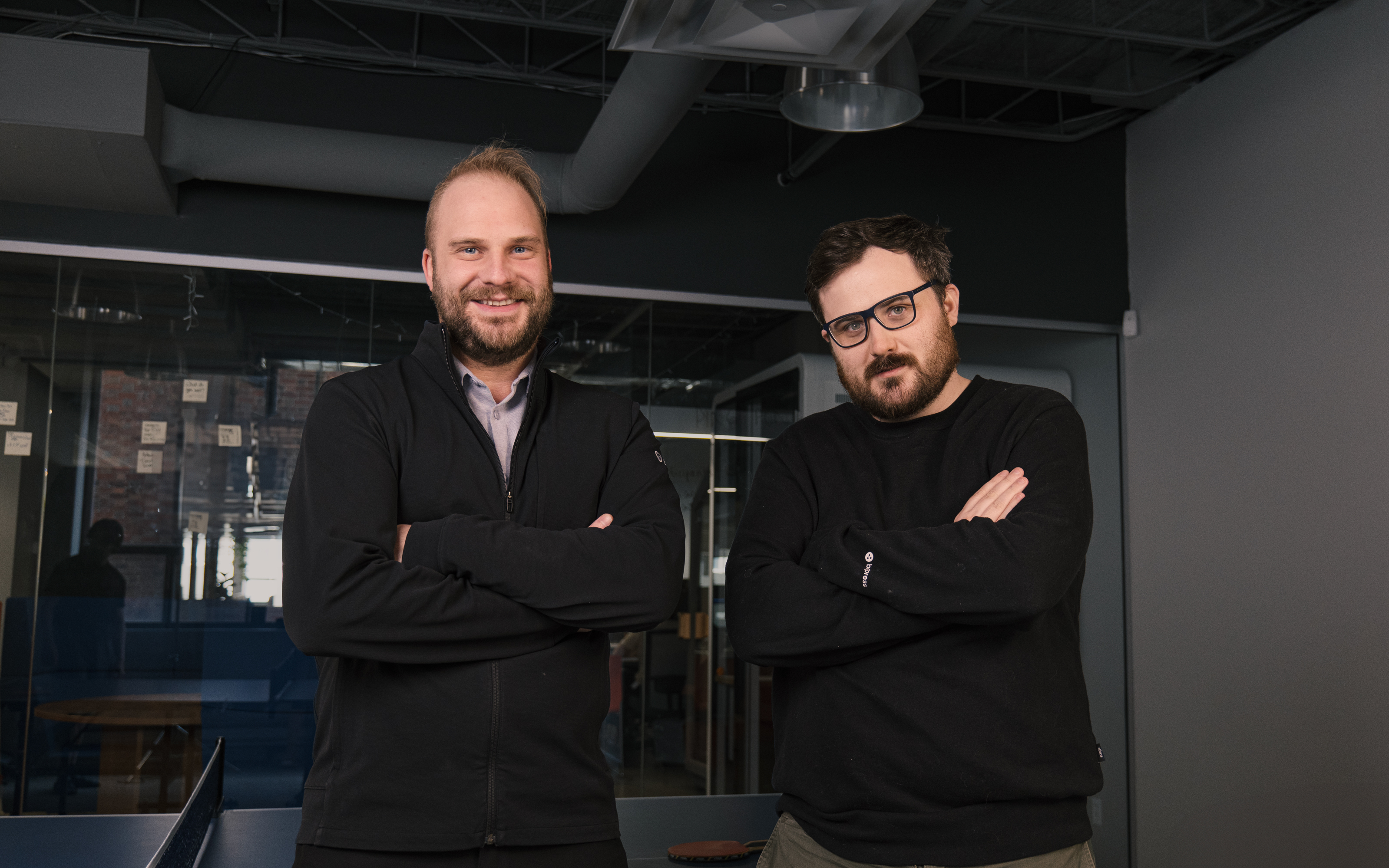 Sylvain Perron, left, and Botpress CFO Jean-Bernard Perron standing together in an office.