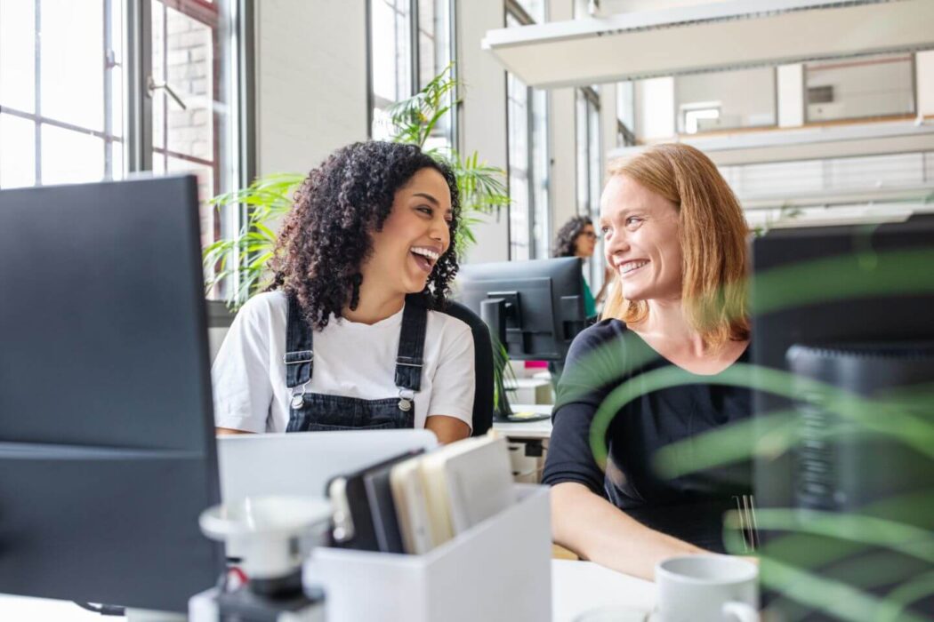 Two colleagues in conversation in a bright workplace