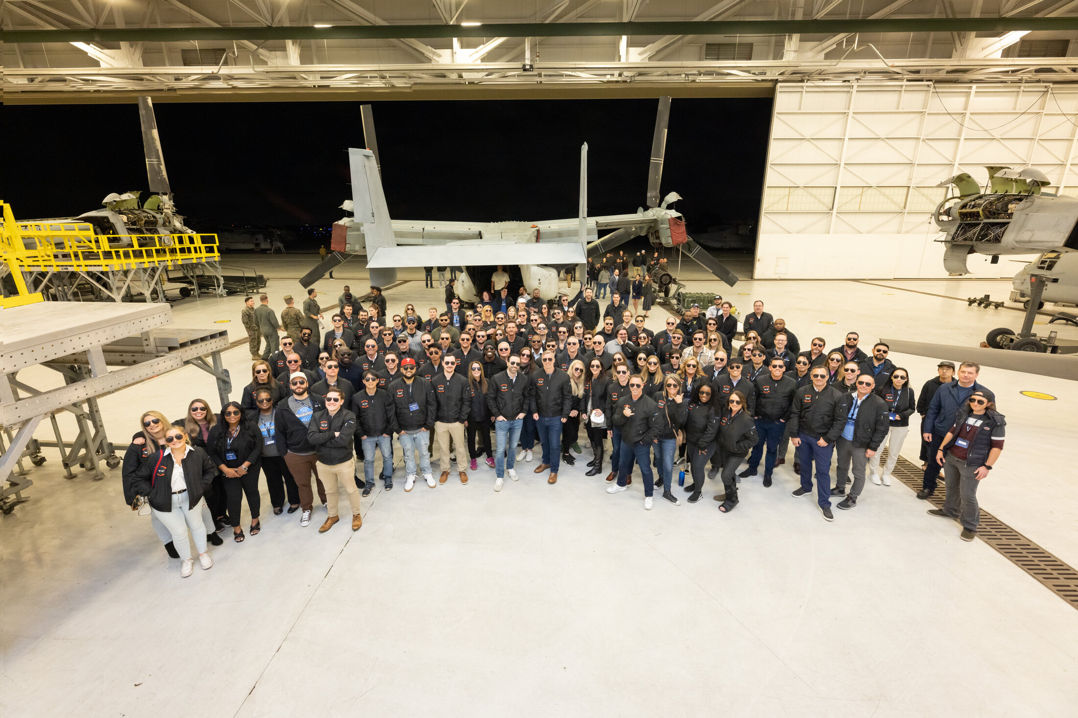 Synack employees gathered in an aircraft hangar in 2023
