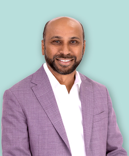 Synergycom founder and CEO Sridhar Guduguntla in a lilac jacket