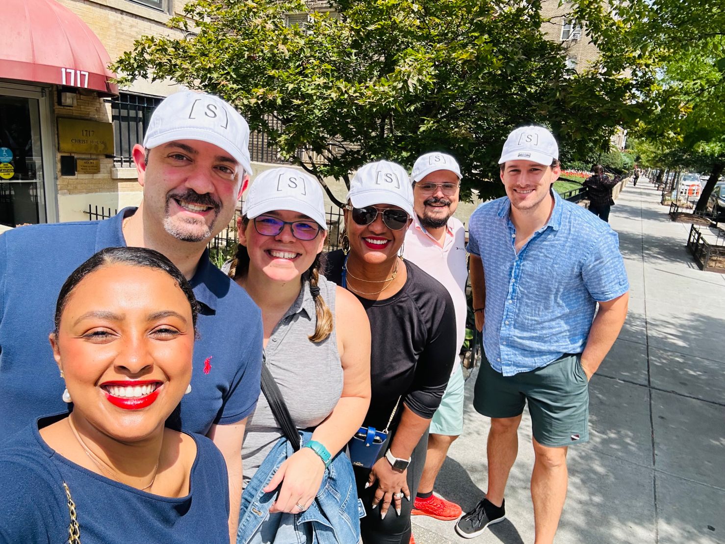 Syntax Health team members outdoors wearing white Syntax caps