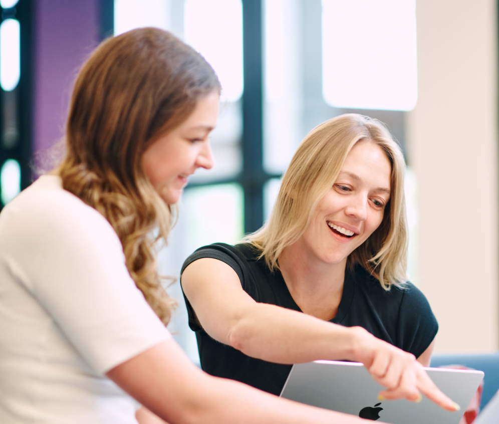 Two colleagues reviewing a laptop in a workplace photograph published by Syntis Bio