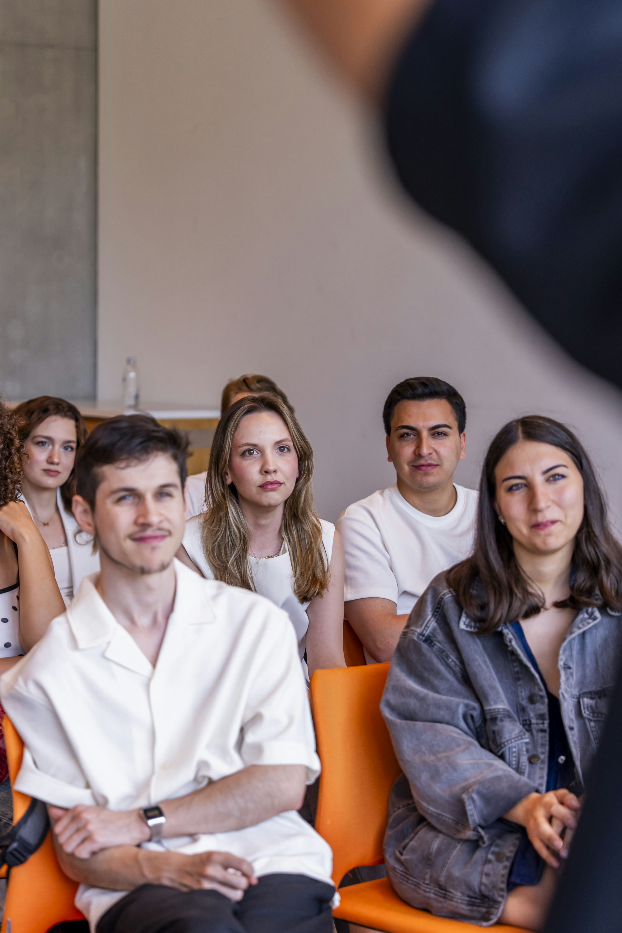 GİRVAK fellows seated in orange chairs, listening during an event