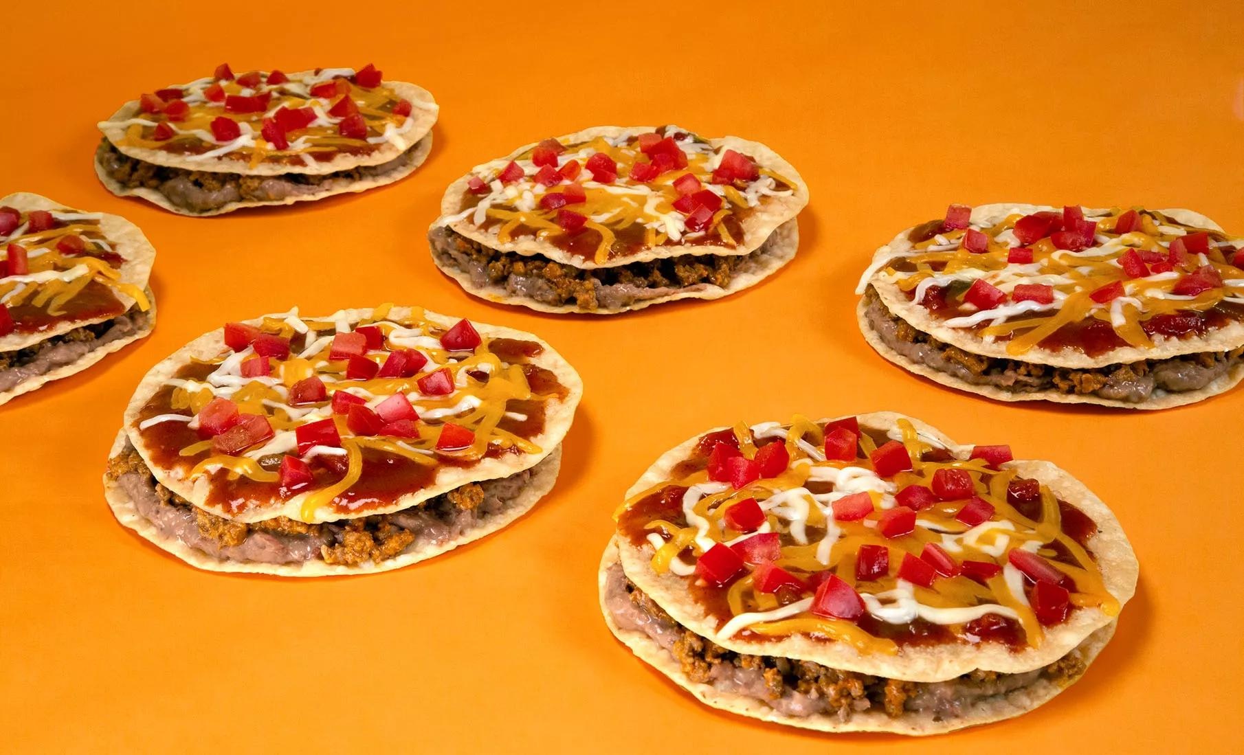 Mexican Pizzas topped with cheese and tomatoes against an orange background