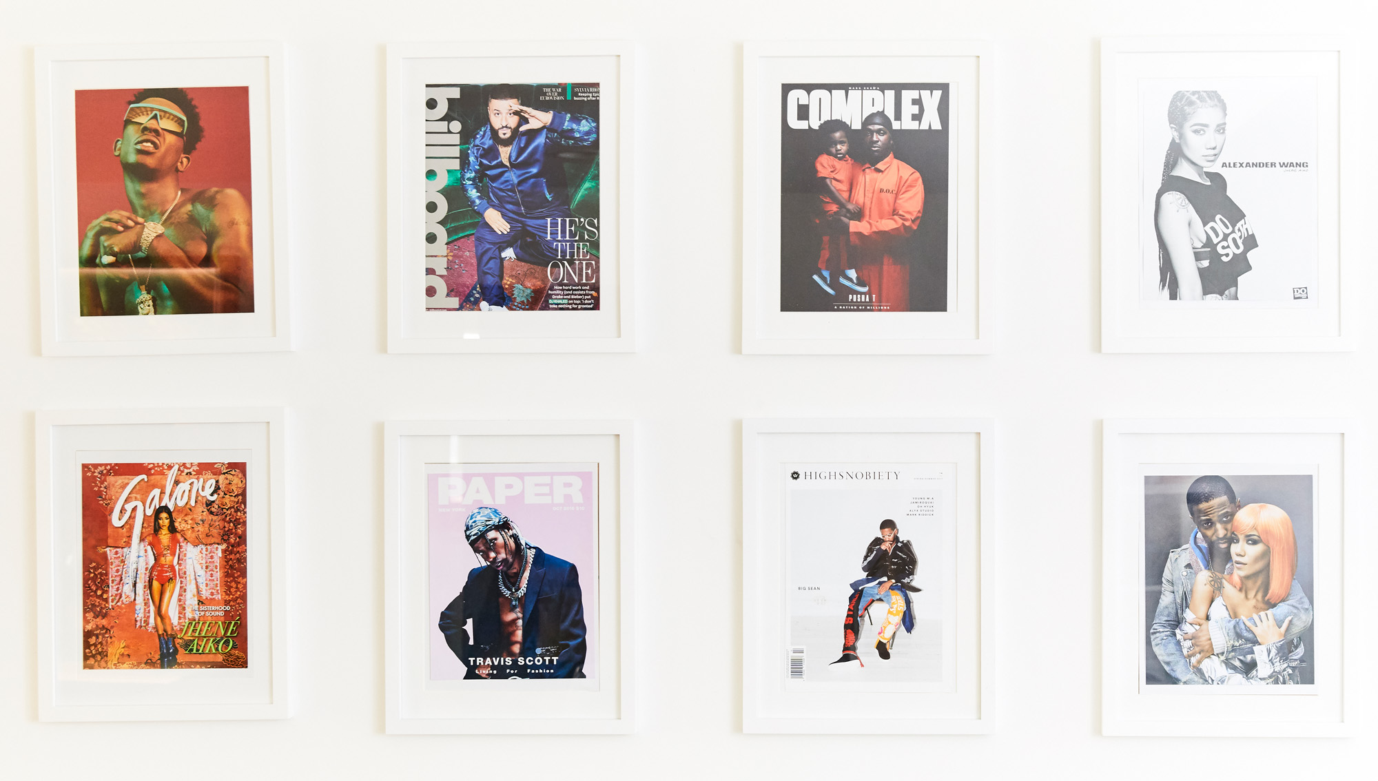 Framed music and fashion magazine covers on the wall of FYI’s office