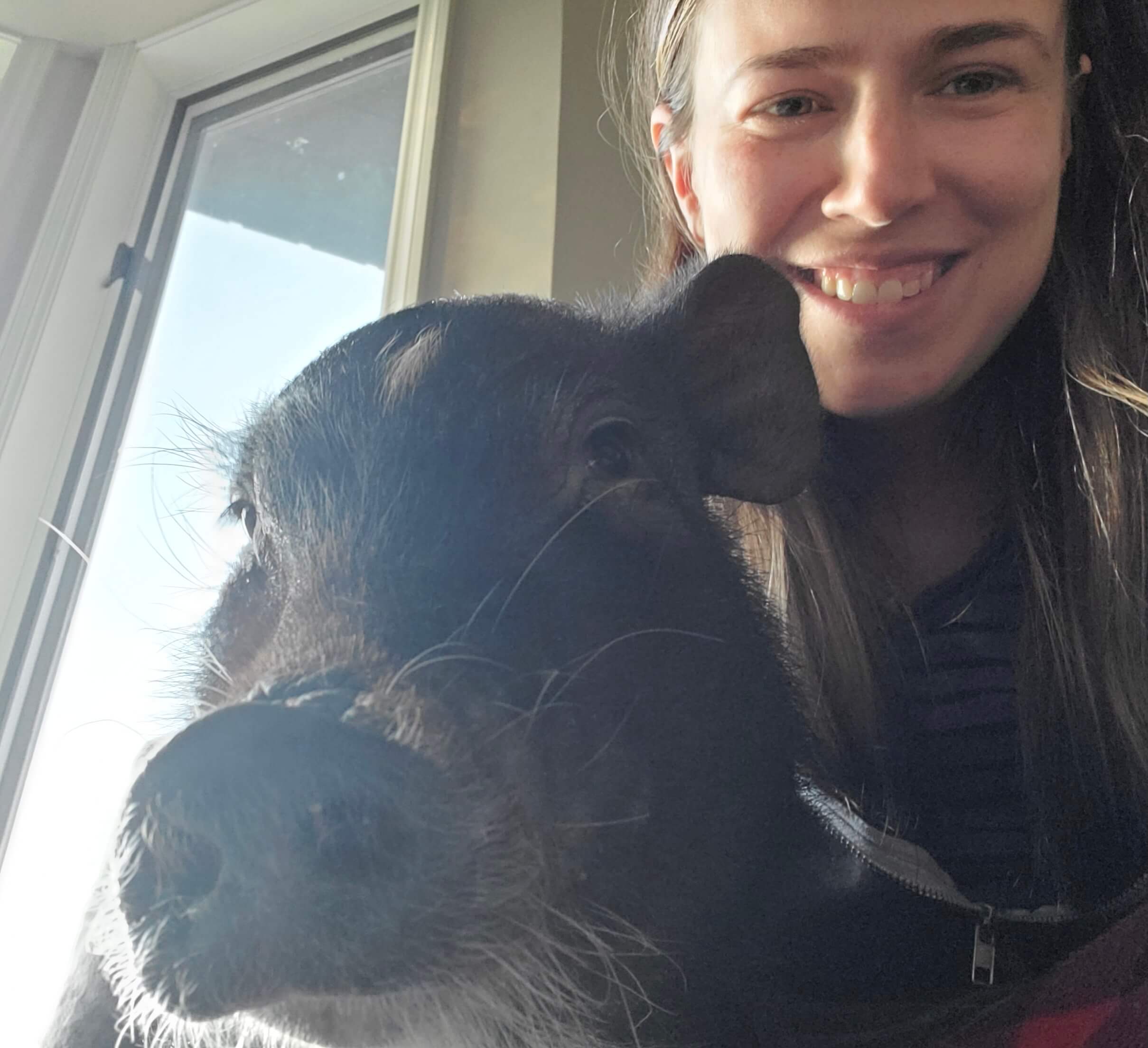 Tania Luna smiling beside Remy, a rescued pig