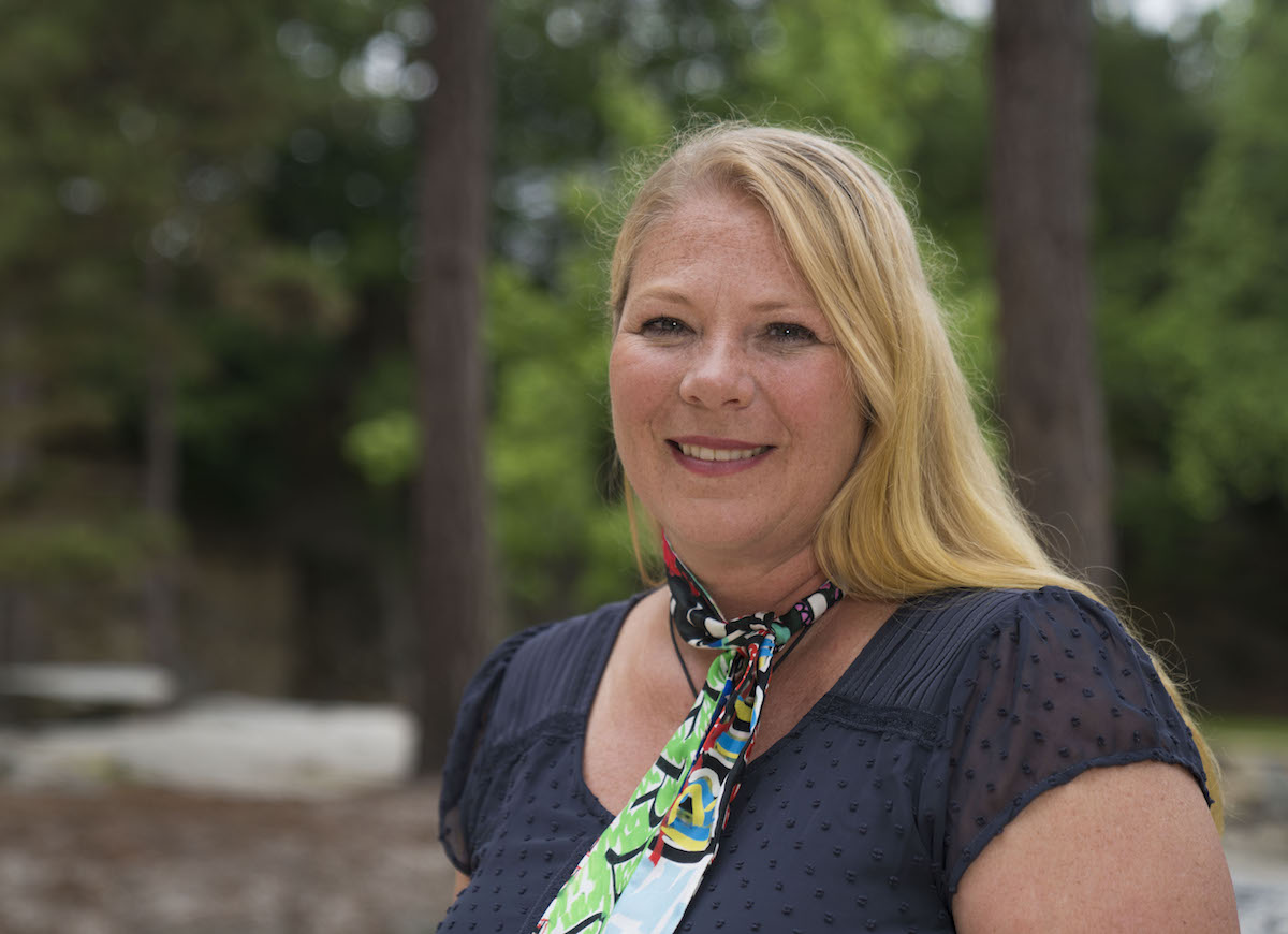 Tara Youngblood outdoors, wearing a navy blouse and a colorful scarf