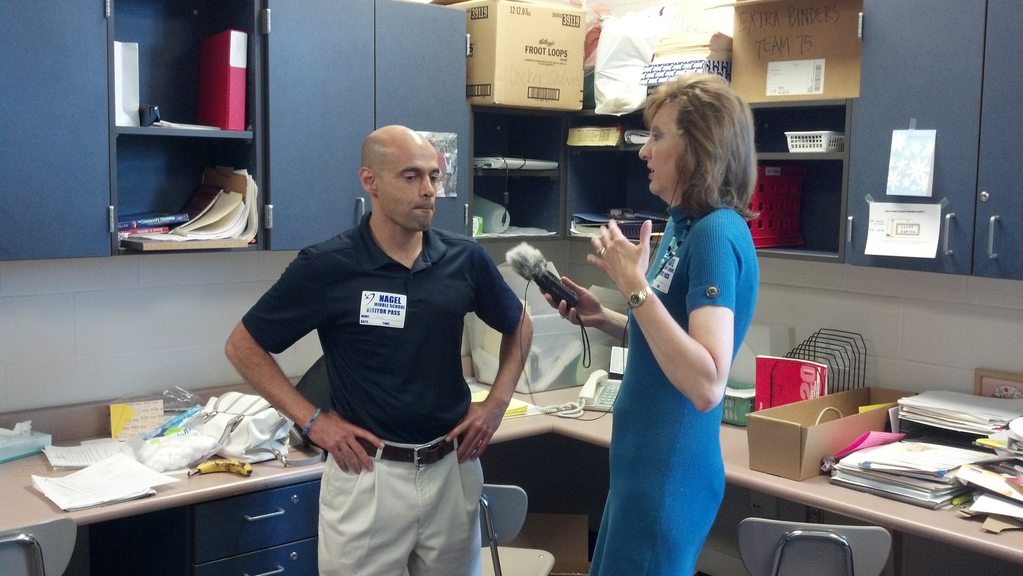 Tarek Kamil speaking with a reporter at Nagel Middle School in 2014