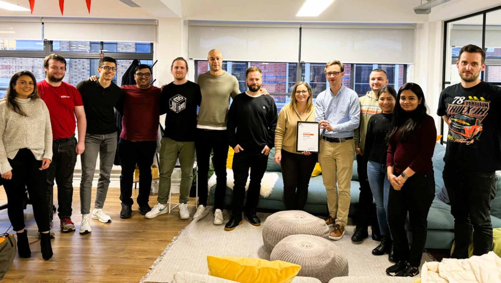 Target Group and AND Digital colleagues who worked on Mortgage Hub gathered in a bright office