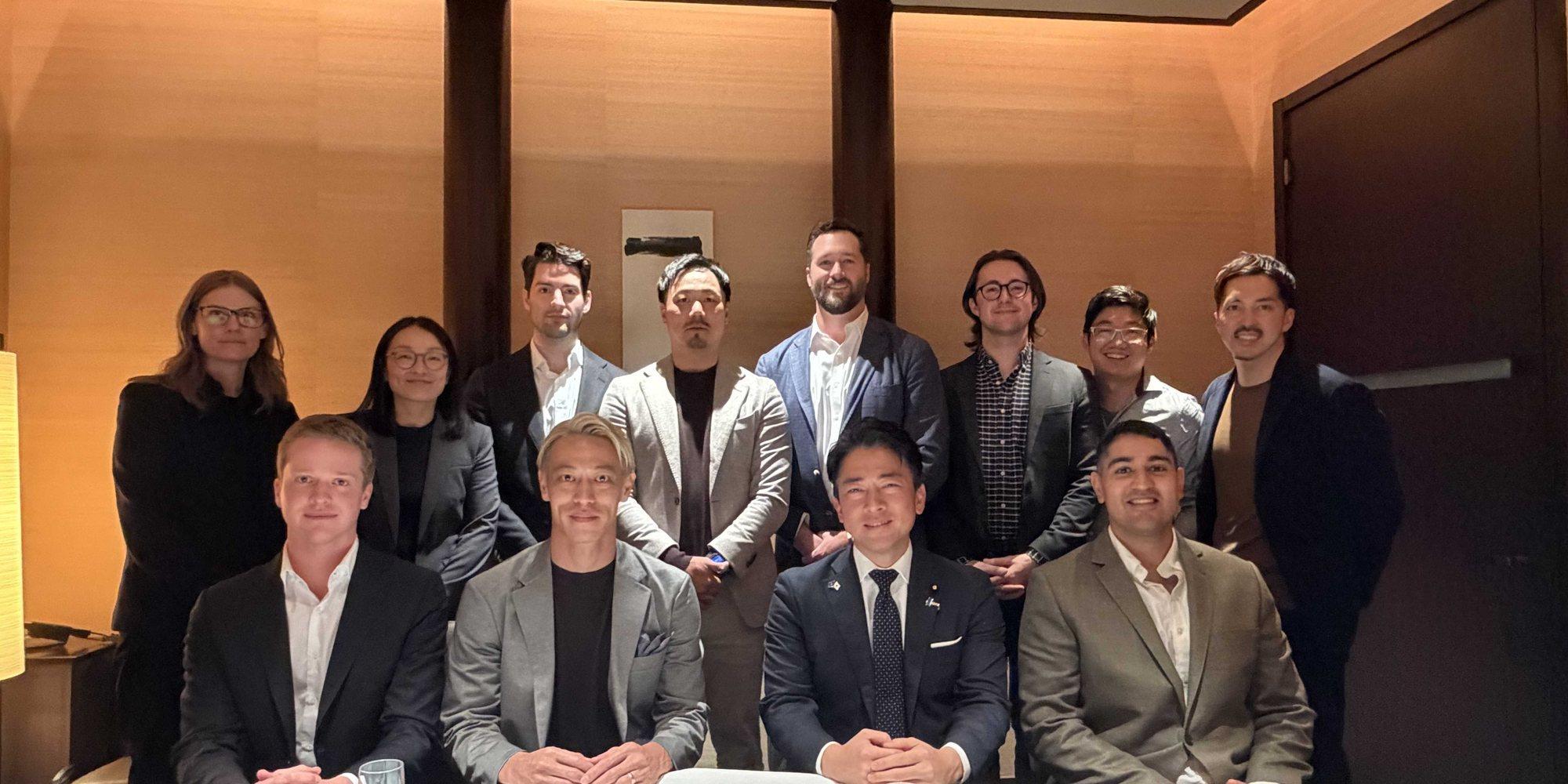 A group of X& partners at a dinner, with Tashi Nakanishi standing in the back row