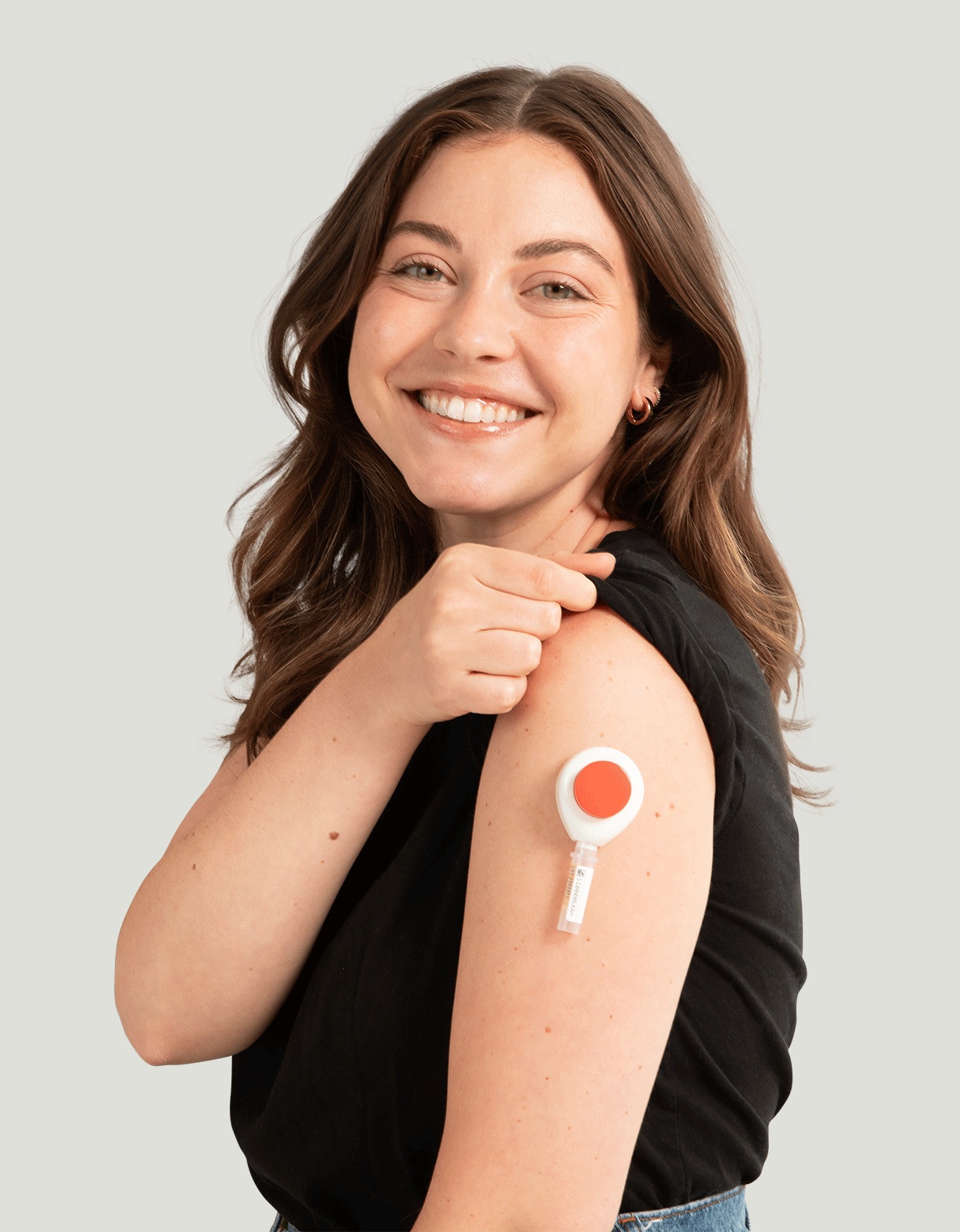 A person wearing a Tasso+ blood collection device on her upper arm