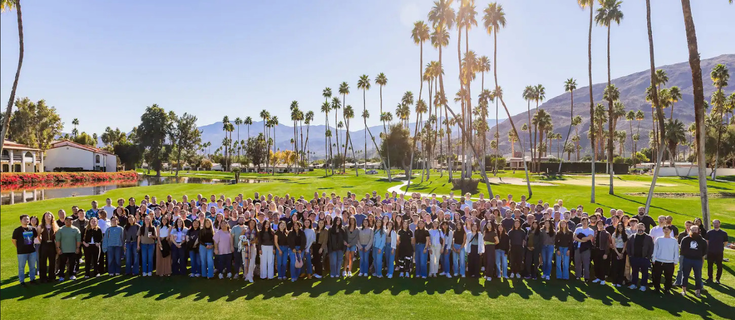 Tatari team gathered outdoors beneath palm trees