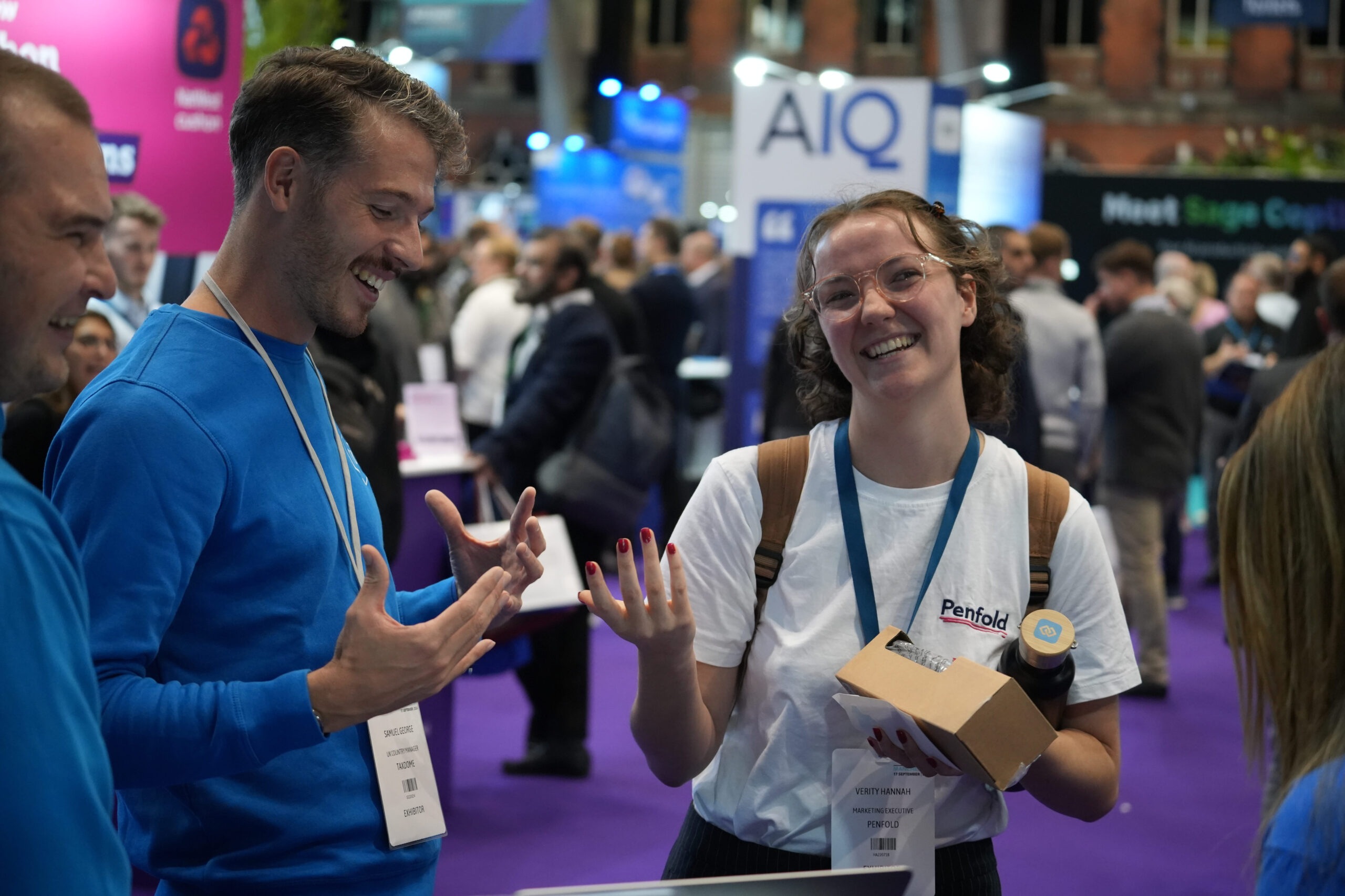 People chatting and smiling at an exhibition, from TaxDome’s company photo gallery