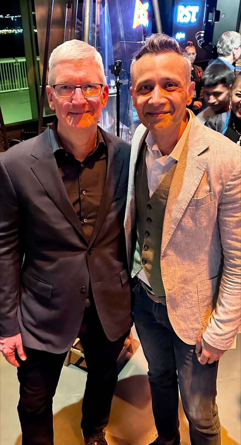Tim Cook on the left and Taymur Ahmad on the right, smiling together at an indoor event